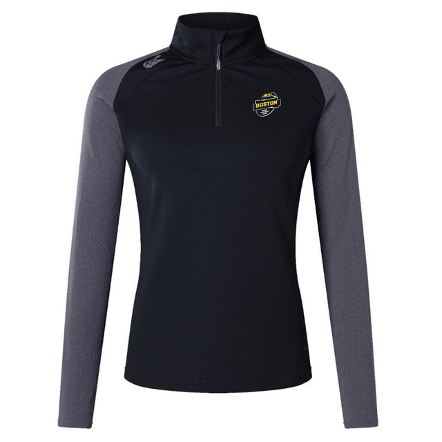 The Boston RFC Women's Elite First Layer by Canterbury, offered by EMB Canterbury, is a black and gray long-sleeve pullover crafted from recycled polyester. It features a half-zip design with a Boston emblem on the chest.