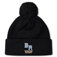 The Ballantyne Ridge Wolves Pom Pom Beanie by EMB Canterbury features a black knit design with cozy fleece lining and "BR Wolves Rugby" embroidered in blue and orange on the front cuff.