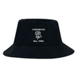 The EMB S&S Activewear Amoskeag Rugby Club Crusher Bucket Cap is a black cotton twill hat with white "AMOSKEAG," an illustrated ram’s head, and "Est. 1984" embroidery—stylish sun protection for any occasion.