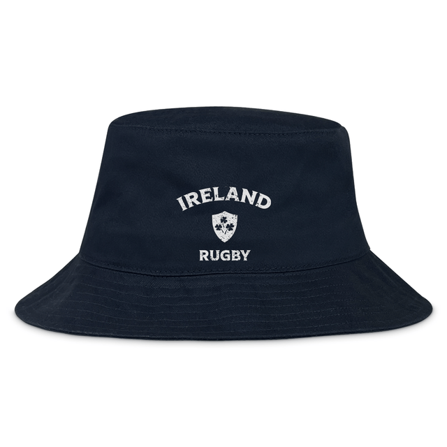 The Nations of Rugby Ireland Rugby Crusher Bucket Hat by EMB S&S Activewear is crafted from cotton twill in navy, featuring “Ireland Rugby” and a white shield emblem embroidered on the front.