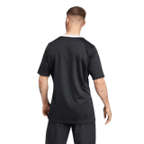 A man in the Black Ferns 24/25 Home Supporters Jersey by adidas, featuring AEROREADY technology, stands against a plain backdrop, wearing black shorts and facing away from the camera.