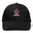 The Chattanooga Queens Rugby Flexfit Drill Cap by EMB Canterbury is a black cap with a curved brim, featuring a red and white embroidered crown logo above "'NOOGA QUEENS WOMEN'S RUGBY" on the front.