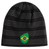 A dark gray knit beanie with bold black horizontal stripes and an EMB Canterbury Brazil Shield Beanie patch prominently on the front.