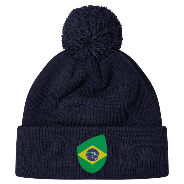 The EMB Canterbury Brazil Shield Pom Pom Beanie in navy blue features a colorful green and yellow patch with a map design, topped with a playful pom pom.