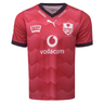 Front of light red with gradient accents jerseys. Vneck style collar with Izuzu & vodacom in white on the rim of the collar. white Puma logo center just below neck. Bulls logo on the left chest and Six Gun Frill on the right chest. Big Vodacom logo center front in white and red.