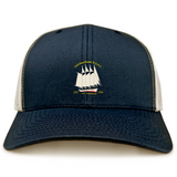 The EMB S&S Activewear Cal Maritime Rugby Retro Trucker Cap is a navy blue and white cap with an embroidered sailing ship and “Coldharbour R.F.L.C. 1927 S/V Tradewind 1998” on the front, finished with a classic snapback closure.