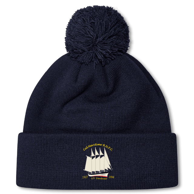The Cal Maritime Rugby Pom Pom Beanie by EMB Canterbury features a navy design with a pom-pom, embroidered white sailing ship, gold "Cal Maritime RLLFC 1927 S/Y Fredawee 1998" text on the cuff, and cozy fleece lining for extra warmth.