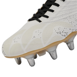 Close-up of the Canterbury Stampede Groundbreak Elite SG - White: a soccer cleat with black laces, textured upper, metallic studs, and light brown sole, echoing traditional soft ground rugby boot design from Canterbury.