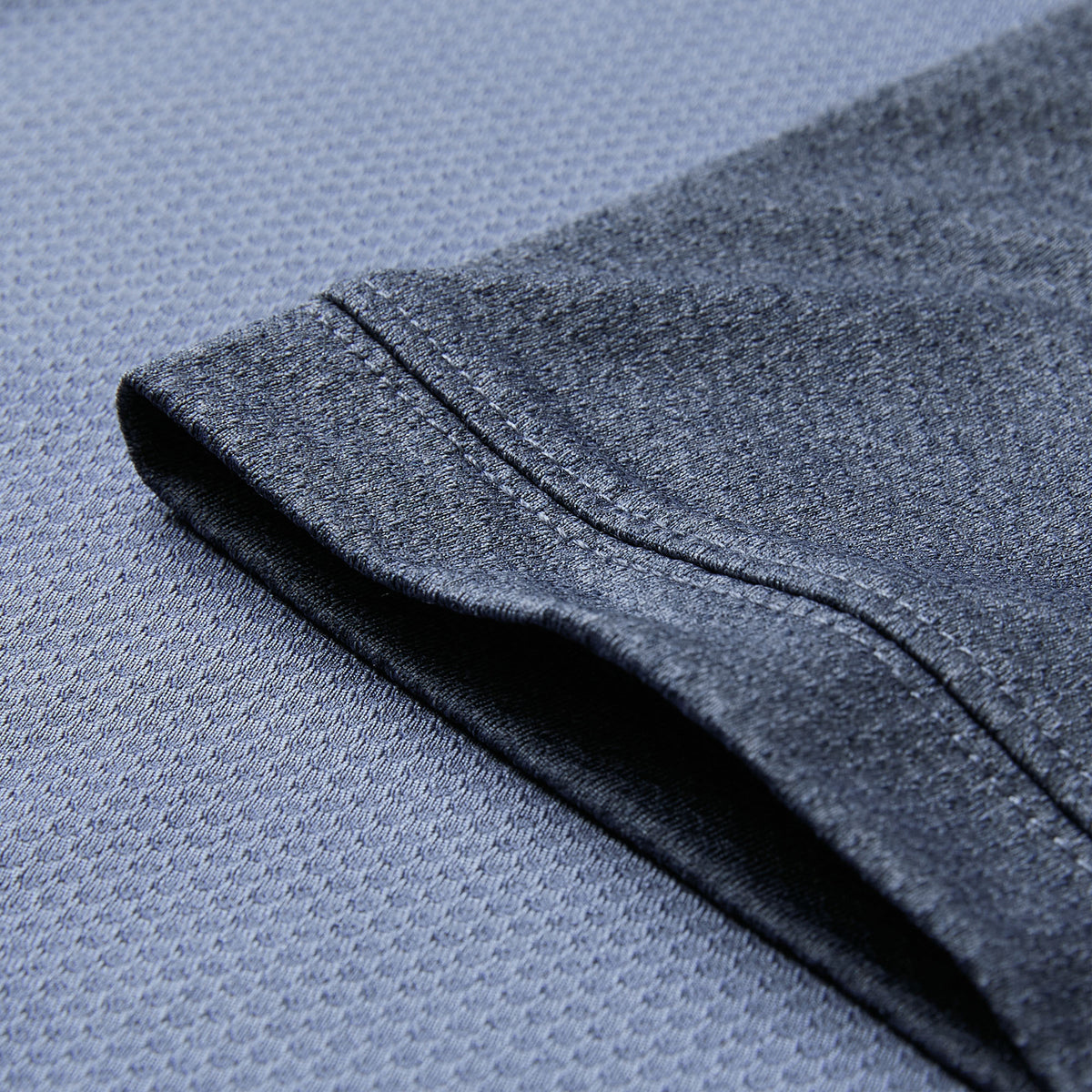 Close-up of a short sleeve on the Canterbury Ireland 26 Poly Polo, laid flat on a textured dark gray background.