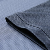 Close-up of a short sleeve on the Canterbury Ireland 26 Poly Polo, laid flat on a textured dark gray background.