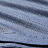 Close-up of blue textured fabric with visible stitching and a subtle diagonal pattern, similar to the premium quality featured in the Ireland 26 Poly Polo by Canterbury.