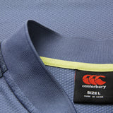 Close-up of the blue textured collar on the Ireland 26 Poly Polo by Canterbury, featuring a yellow inner trim and a black Canterbury label marked “SIZE L” and “MADE IN CHINA.”.