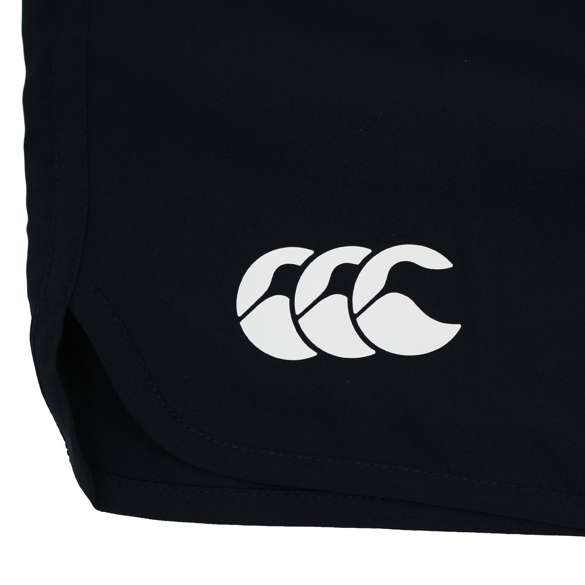Close-up of the lower part of the Women’s Ireland 26 6″ Woven Gym Short by Canterbury in black, featuring a white Canterbury logo with three overlapping shapes, typically seen on women’s athletic shorts.