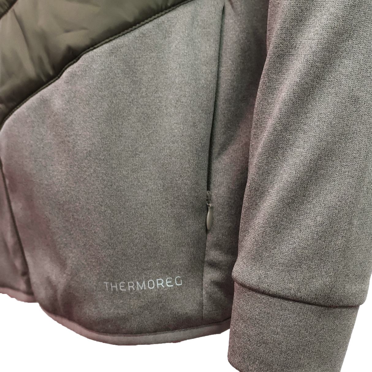 Close-up of a gray Canterbury Ireland 25/26 Hybrid Padded Jacket sleeve and side pocket, featuring "THERMOREG" near the hem to showcase its ThermoReg heat retention technology.