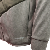 Close-up of a gray Canterbury Ireland 25/26 Hybrid Padded Jacket sleeve and side pocket, featuring "THERMOREG" near the hem to showcase its ThermoReg heat retention technology.