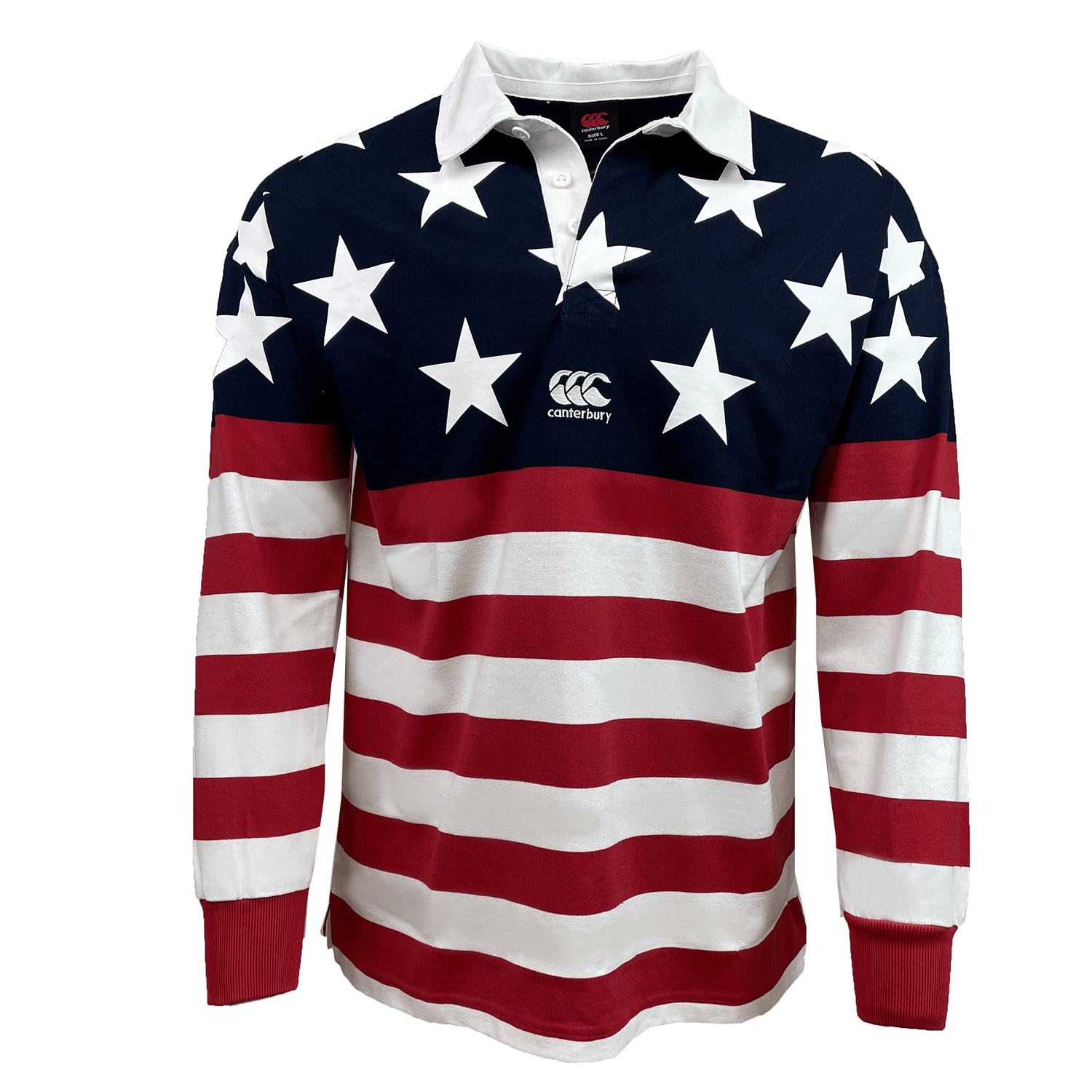 The Canterbury USA Flag Heritage Long Sleeve Rugger by Canterbury features a design with white stars on a blue background on the chest and sleeves, complemented by red and white horizontal stripes on the lower part and the sleeves.