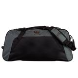 The Canterbury Holdall Duffle Bag by Canterbury in black and gray features a logo on the front and strap, includes a shoulder strap, and is water-repellent—ideal for carrying your rugby essentials while protecting your gear.