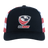 The EMB Augusta USA Rugby Crest Flag Cap is black and white with red and white striped sides, featuring the USA Rugby eagle logo and text on the front.