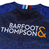 Close-up of the Blues Super Rugby Home Jersey 24 by Classic Sportswear, crafted from moisture-wicking fabric and featuring the white and orange "Barfoot & Thompson" logo on the back, ideal for Super Rugby matches.