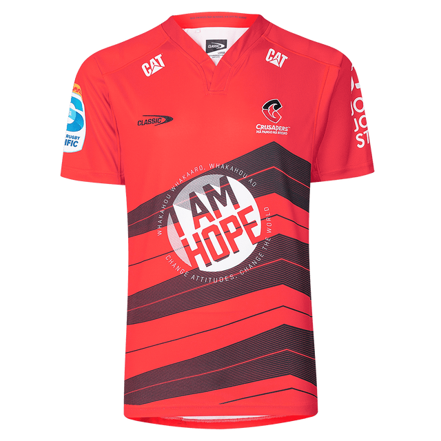 The Crusaders Super Rugby Replica Home Jersey 25/26 by Classic Sportswear features sponsor logos, the "Classic" logo, and the "Crusaders" team logo. It showcases "I AM HOPE" on the front, making it essential for any Super Rugby enthusiast.