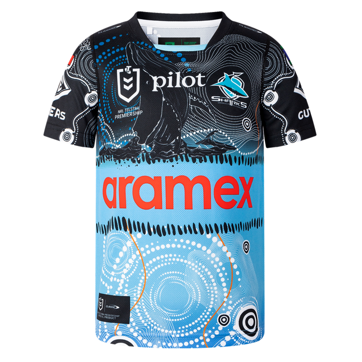The Sharks Indigenous NRL 25/26 Replica Jersey by Classic Sportswear features Indigenous-inspired black, blue, and white patterns, with "Aramex" and "Pilot" sponsor logos on the front and the Sharks team logo on the chest.