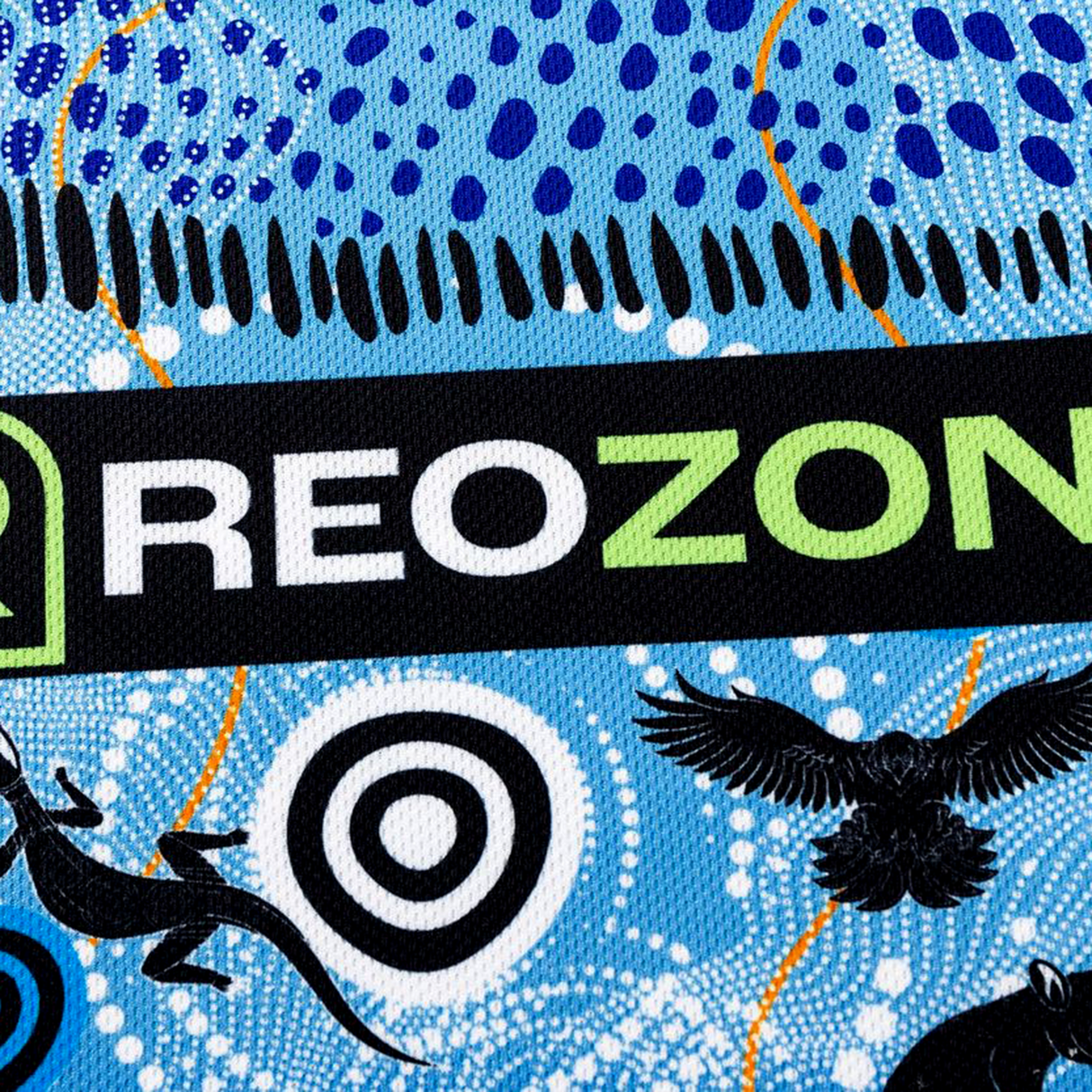 A close-up of the Sharks Indigenous NRL 25/26 Replica Jersey by Classic Sportswear, showing "REOZONE" in bold, blue dotted patterns, black animal silhouettes, and concentric circles inspired by Indigenous design.