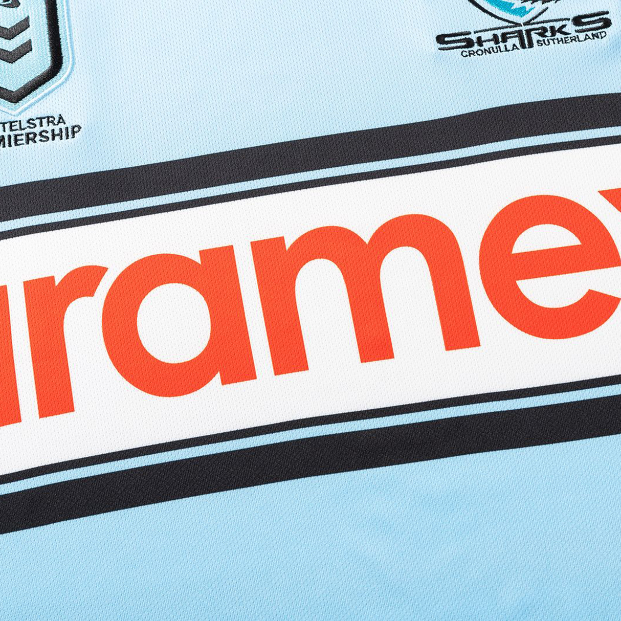 Close-up of the Sharks NRL 26/27 Replica Home Jersey by Classic Sportswear, with the team's and NRL logos plus a bold red sponsor name on a light blue background.