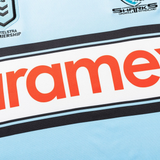 Close-up of the Sharks NRL 26/27 Replica Home Jersey by Classic Sportswear, with the team's and NRL logos plus a bold red sponsor name on a light blue background.