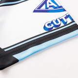 Close-up of the Sharks NRL 26/27 Replica Home Jersey by Classic Sportswear, showing a geometric blue-purple logo, "GUTT" text, and black and blue accents on crisp white fabric.