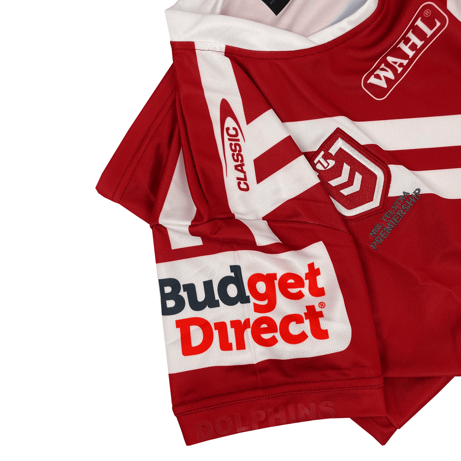 The Dolphins NRL 25/26 Special Edition Heritage Jersey by Classic Sportswear features vibrant red with white logos and "Budget Direct," "Dolphins," and "Classic," honoring Rugby League history and the team's enduring legacy.