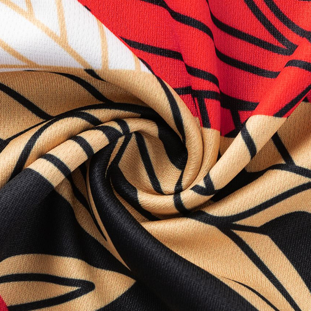 Close-up of the Dolphins Indigenous NRL 25/26 Replica Jersey by Classic Sportswear, featuring a vibrant swirling pattern in red, beige, black, and white with bold graphic lines.