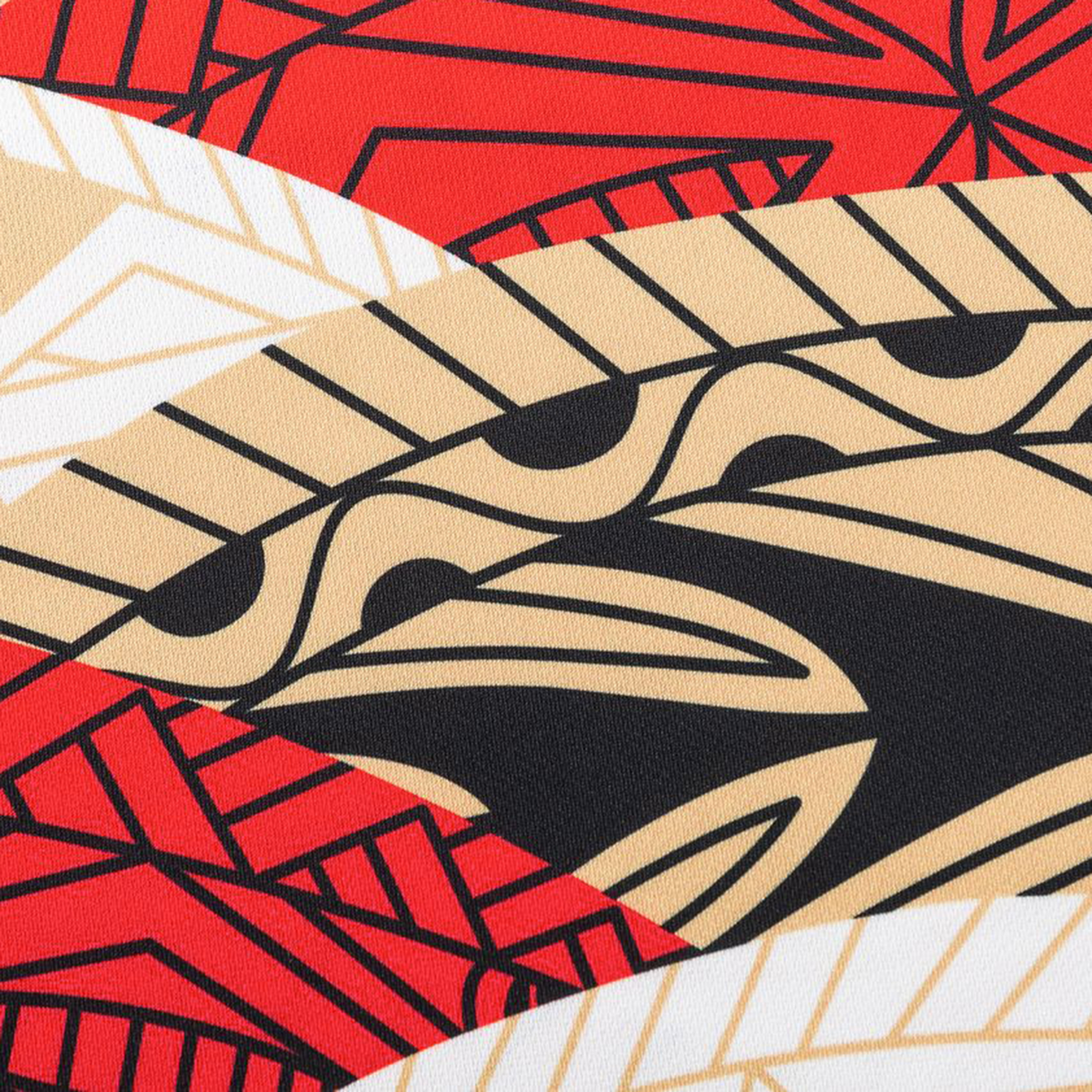 A close-up of fabric with bold, abstract geometric patterns in red, black, beige, and white—featured on the Dolphins Indigenous NRL 25/26 Replica Jersey by Classic Sportswear.