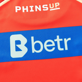 Close-up of the Dolphins NRL 26/27 Replica Home Jersey by Classic Sportswear—authentic red design with "PHINS UP" at the top and a blue stripe featuring the "betr" logo.