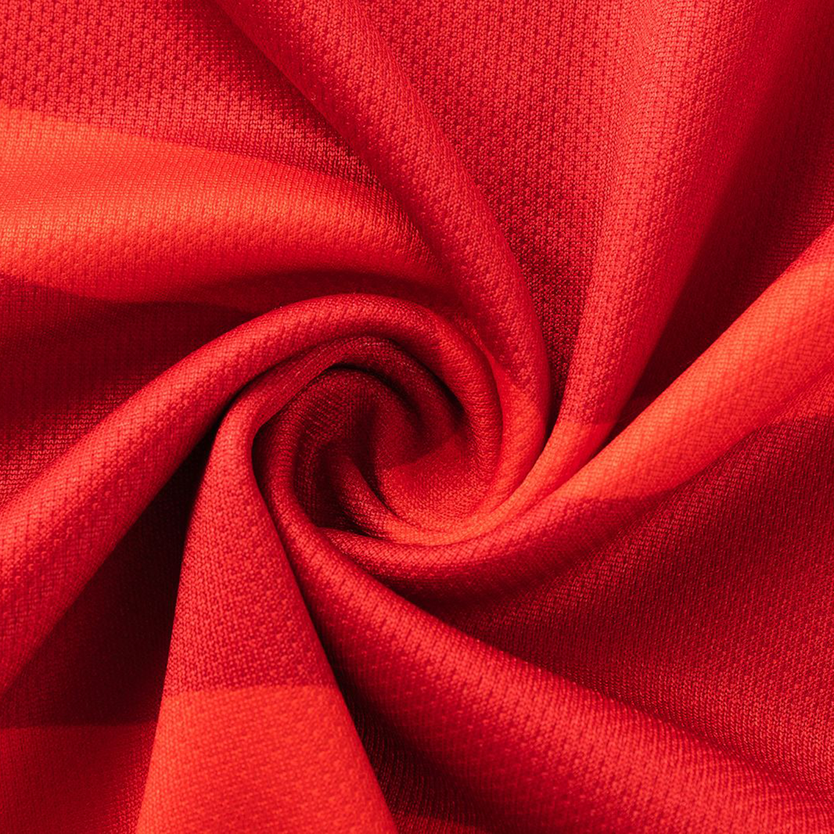 Close-up of vibrant red fabric with a textured pattern, twisted into a spiral—evoking the dynamic material of the Dolphins NRL 26/27 Replica Home Jersey by Classic Sportswear.