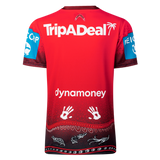 The back of the Dragons Indigenous NRL 25/26 Replica Jersey by Classic Sportswear features "TripADeal" and "dynamoney" logos, handprint graphics, blue sponsor patches, and a patterned black trim at the bottom.