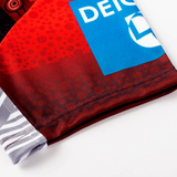 Close-up of the Dragons Indigenous NRL 25/26 Replica Jersey by Classic Sportswear, showing red and black geometric patterns and a blue rectangular "DEICH" logo.