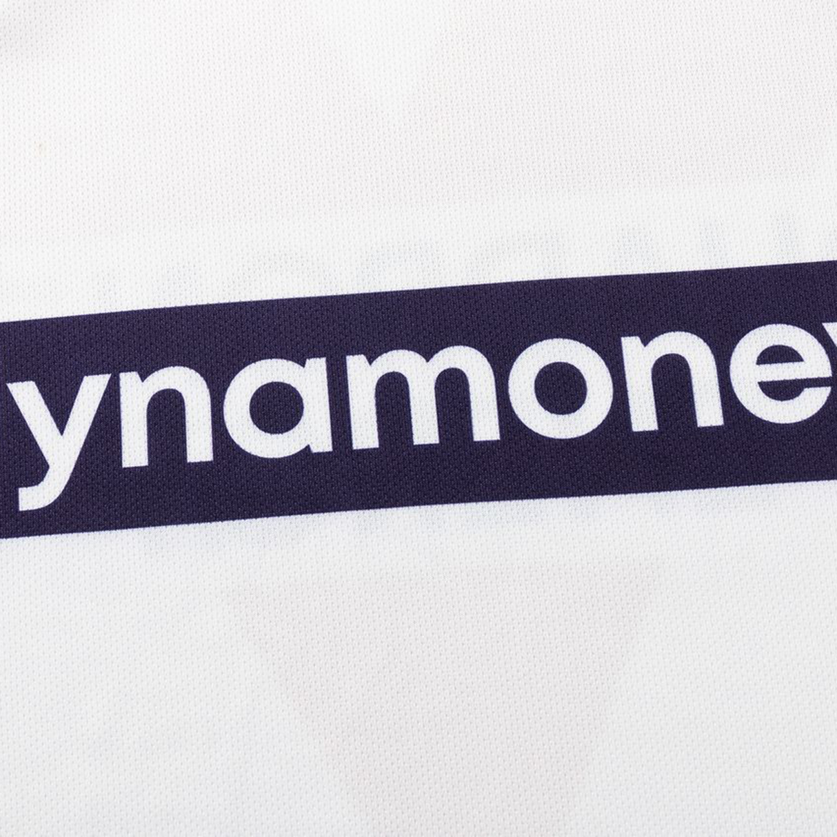 A close-up of white fabric with partial "ynamone" text in bold white letters on a dark stripe, from the Dragons NRL 26/27 Replica Home Jersey by Classic Sportswear.