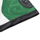 A close-up of a green and black fabric, adorned with sublimated graphics and English/Maori text, resembles the NRL Maori All Stars 25/26 Replica Home Jersey by Classic Sportswear. The material's anti-microbial wickable properties ensure comfort and durability.