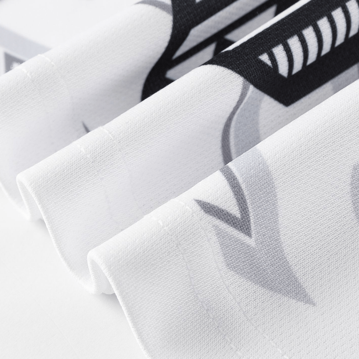 Close-up of the NRL Maori All Stars 25/26 Replica Home Jersey by Classic Sportswear, featuring folded white fabric with bold, abstract black and gray designs and sharp angles reminiscent of sublimated graphics.