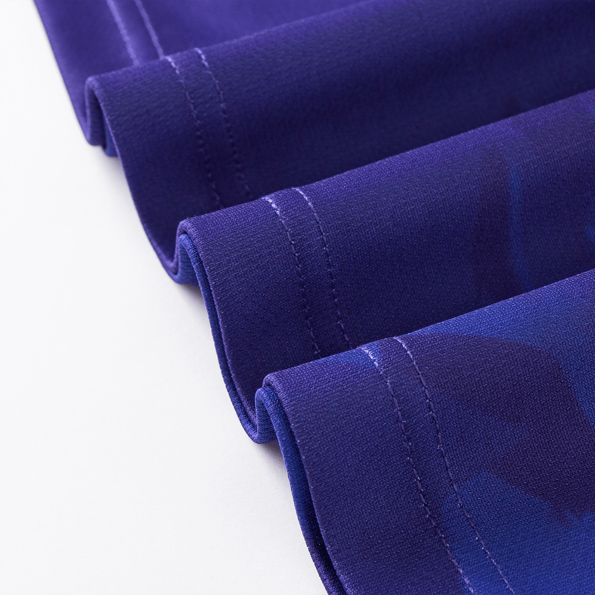 Close-up of blue fabric with neat stitching along the edges, displaying a folded arrangement reminiscent of a Knights NRL Heritage Jersey by Classic Sportswear in classic sportswear style.