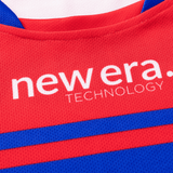 Close-up of a fabric featuring red and blue sections with the words "new era. TECHNOLOGY" printed in white text, reminiscent of a Knights NRL Heritage Jersey by Classic Sportswear worn by the Newcastle Knights.