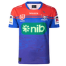 A blue and red sports jersey with the text "nib" displayed prominently on the front. This Knights NRL Heritage Jersey by Classic Sportswear, adorned with several sponsor logos, proudly showcases the team emblem of the Newcastle Knights.