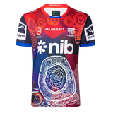 The Knights Indigenous NRL 25/26 Replica Jersey by Classic Sportswear features striking red, blue, and white patterns, sponsor logos, and cultural artwork on the front—celebrating team heritage and pride.