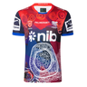 The Knights Indigenous NRL 25/26 Replica Jersey by Classic Sportswear features striking red, blue, and white patterns, sponsor logos, and cultural artwork on the front—celebrating team heritage and pride.