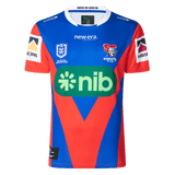The Knights NRL 25/26 Replica Home Jersey by Classic Sportswear features logos from NIB, New Era, and McDonald's. It boasts an athletic fit with vibrant sublimated graphics that capture the spirit of the game perfectly.