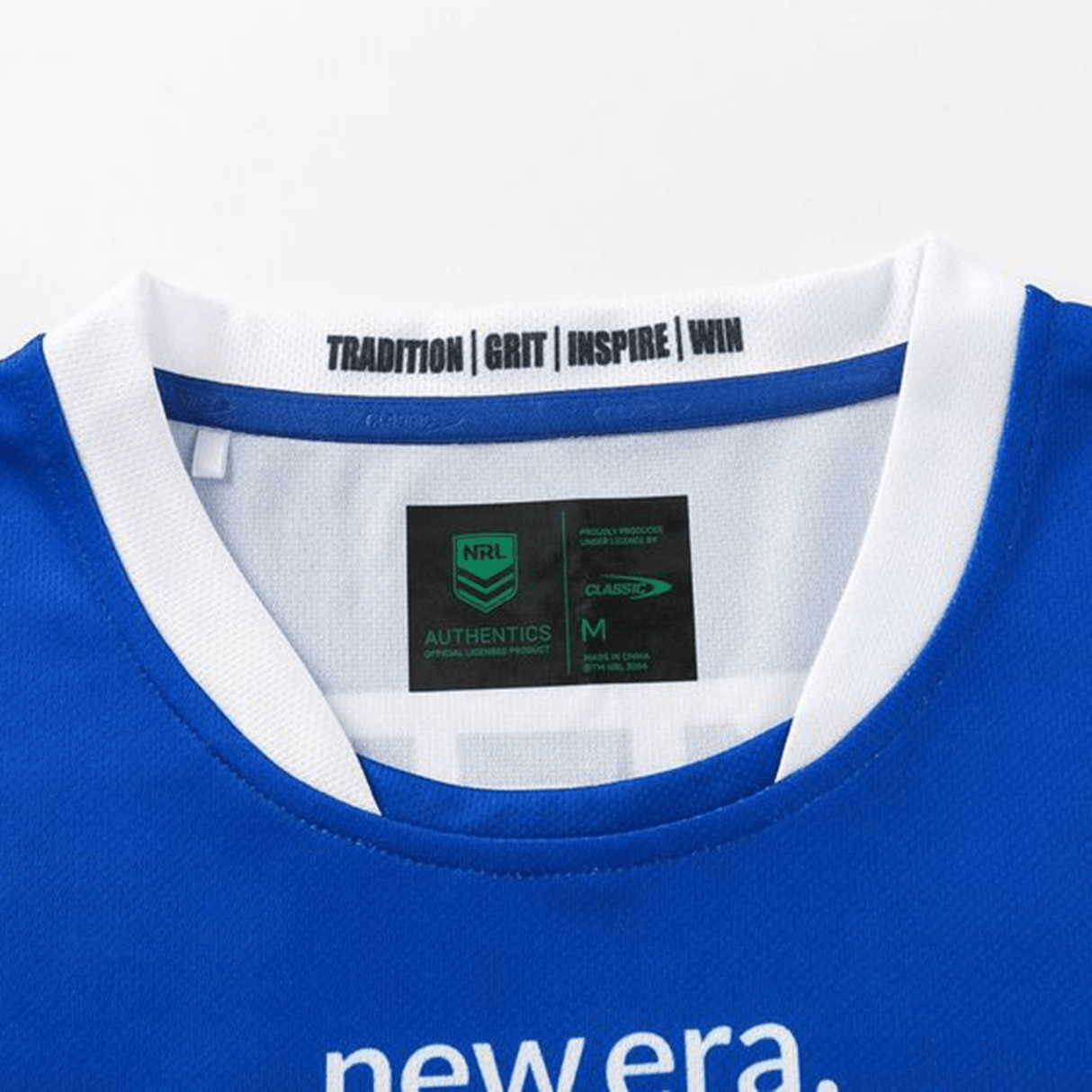 Close-up of the Knights NRL 25/26 Replica Home Jersey by Classic Sportswear, featuring an athletic fit and sublimated graphics. The blue and white jersey has neck labels reading "TRADITION | GRIT | INSPIRE | WIN" and "newera," plus NRL Authentic and Classic Sportswear tags.