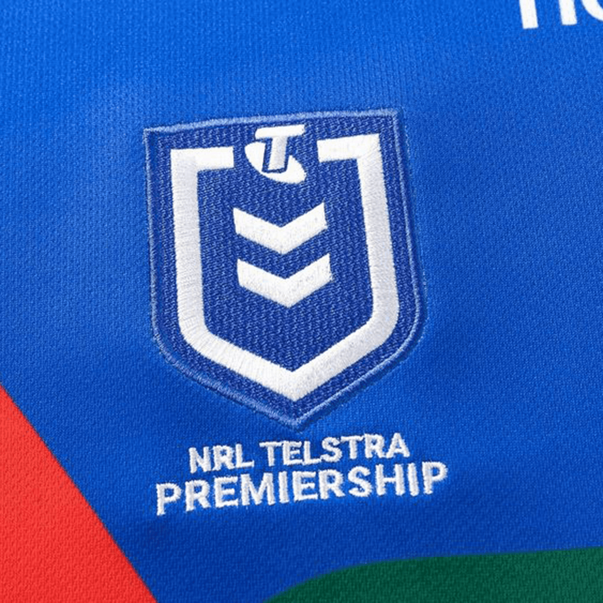 The NRL Telstra Premiership logo is elegantly displayed on a blue fabric background, reminiscent of the Knights NRL 25/26 Replica Home Jersey by Classic Sportswear with its athletic fit and sublimated graphics.