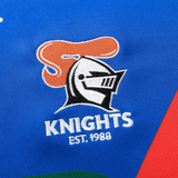 A sublimated logo featuring a knight's helmet with "KNIGHTS" and "EST. 1988" adorns the blue fabric of the Knights NRL 25/26 Replica Home Jersey by Classic Sportswear.