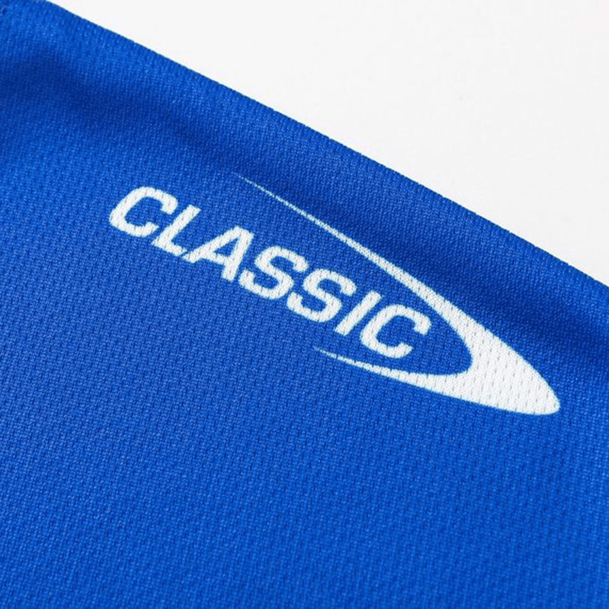 Close-up of a blue fabric featuring "CLASSIC" in white with a swoosh, similar to the Knights NRL 25/26 Replica Home Jersey's athletic fit and sublimated graphics by Classic Sportswear.