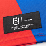 Close-up of the Knights NRL 25/26 Replica Home Jersey by Classic Sportswear, showcasing a red and blue design with sublimated graphics and an NRL Telstra Premiership official product label.